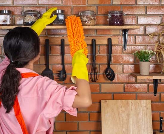 Modular kitchen cleaning services dusting cupboard